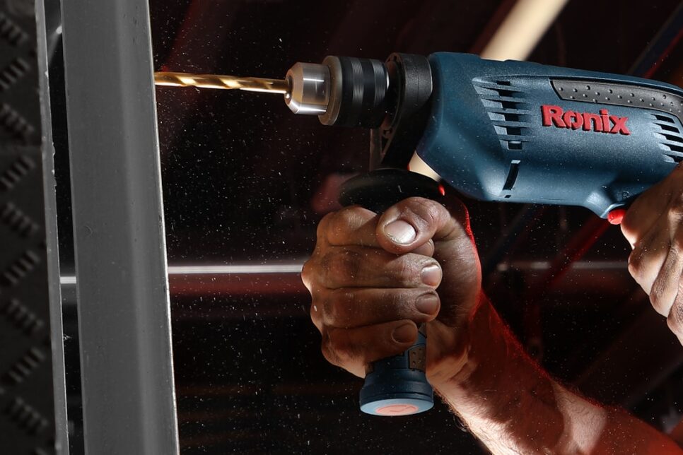 person holding blue and black cordless power drill