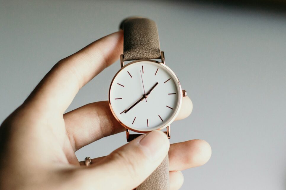 person holding analog watch