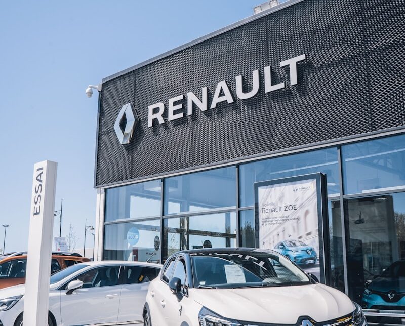 a white car is parked in front of a dealership