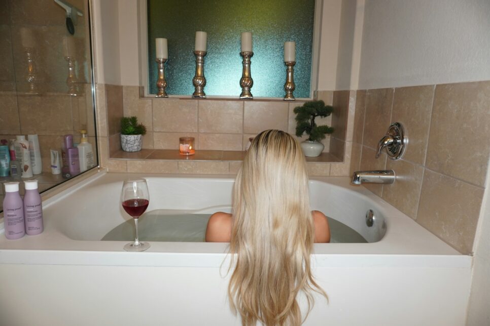 A woman sitting in a bathtub with a glass of wine