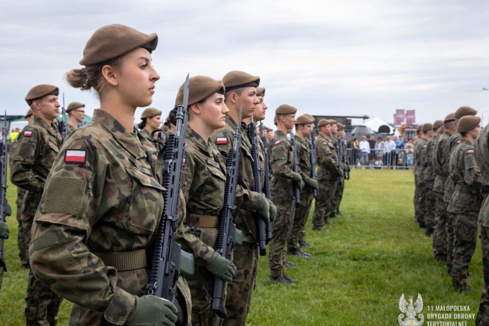 Polska flaga na niebie i uroczysta przysięga małopolskich terytorialsów na lotnisku w Pobiedniku Wielkim. Małopolska