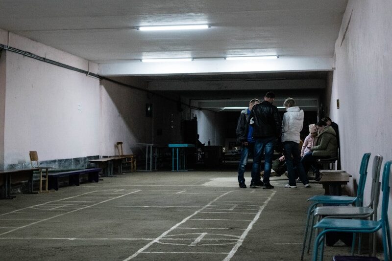 a group of people standing in a room with a tile floor