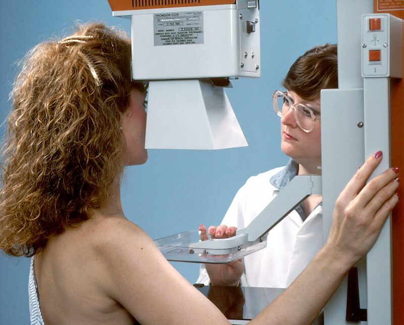 woman in white tube top holding white printer paper