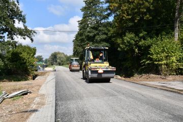 Układanie nawierzchni bitumicznej na drodze powiatowej w miejscowości Pstroszyce Drugie. Powiat miechowski