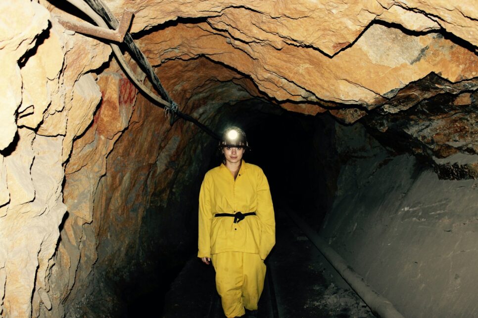 woman wearing yellow overall standing under cave