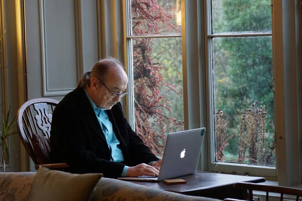 man in black suit jacket using macbook